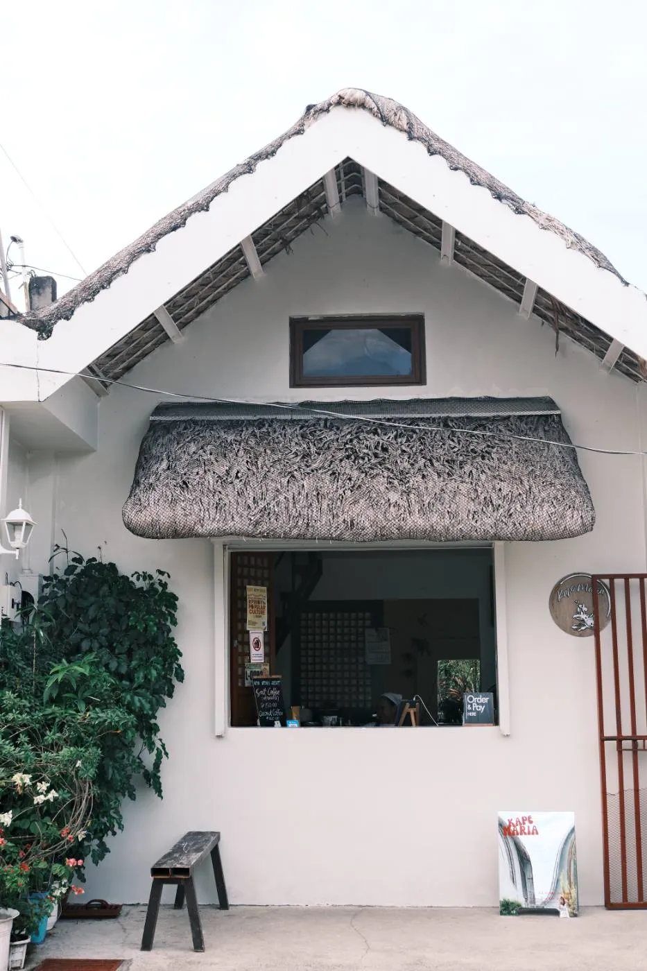 The white nipa-roofed Kape Maria coffee house front