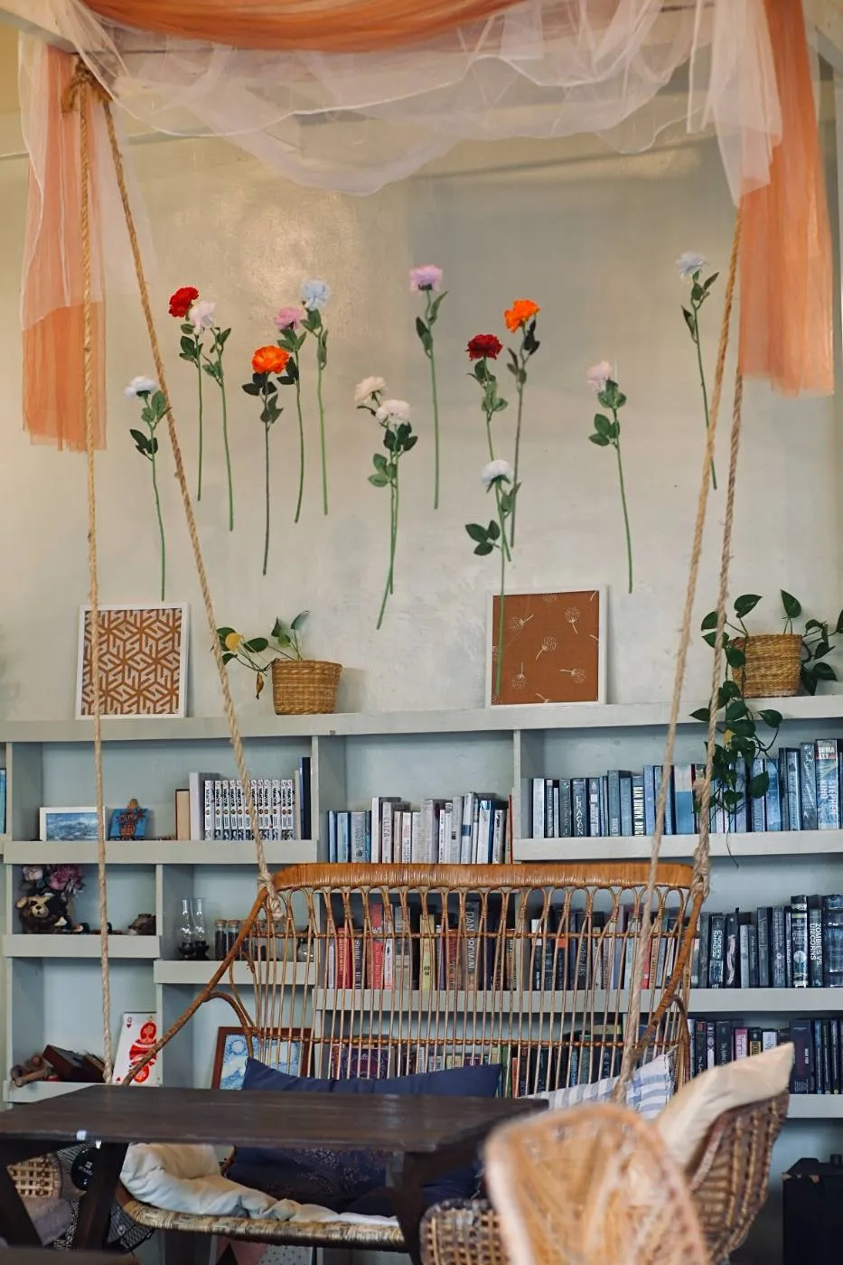 The book shelves and flower wall by the hanging swing