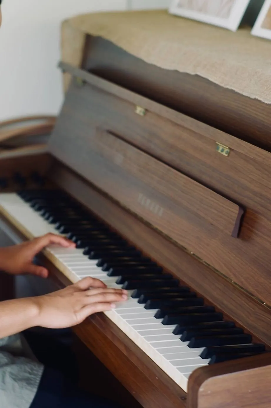 Hands playing the upright piano in the coffee house